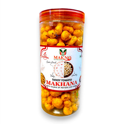 A clear plastic jar of Makno Tangy Tomato Makhana (split chickpeas) filled with golden-brown fried chickpeas, featuring a white and red label, on a white background.