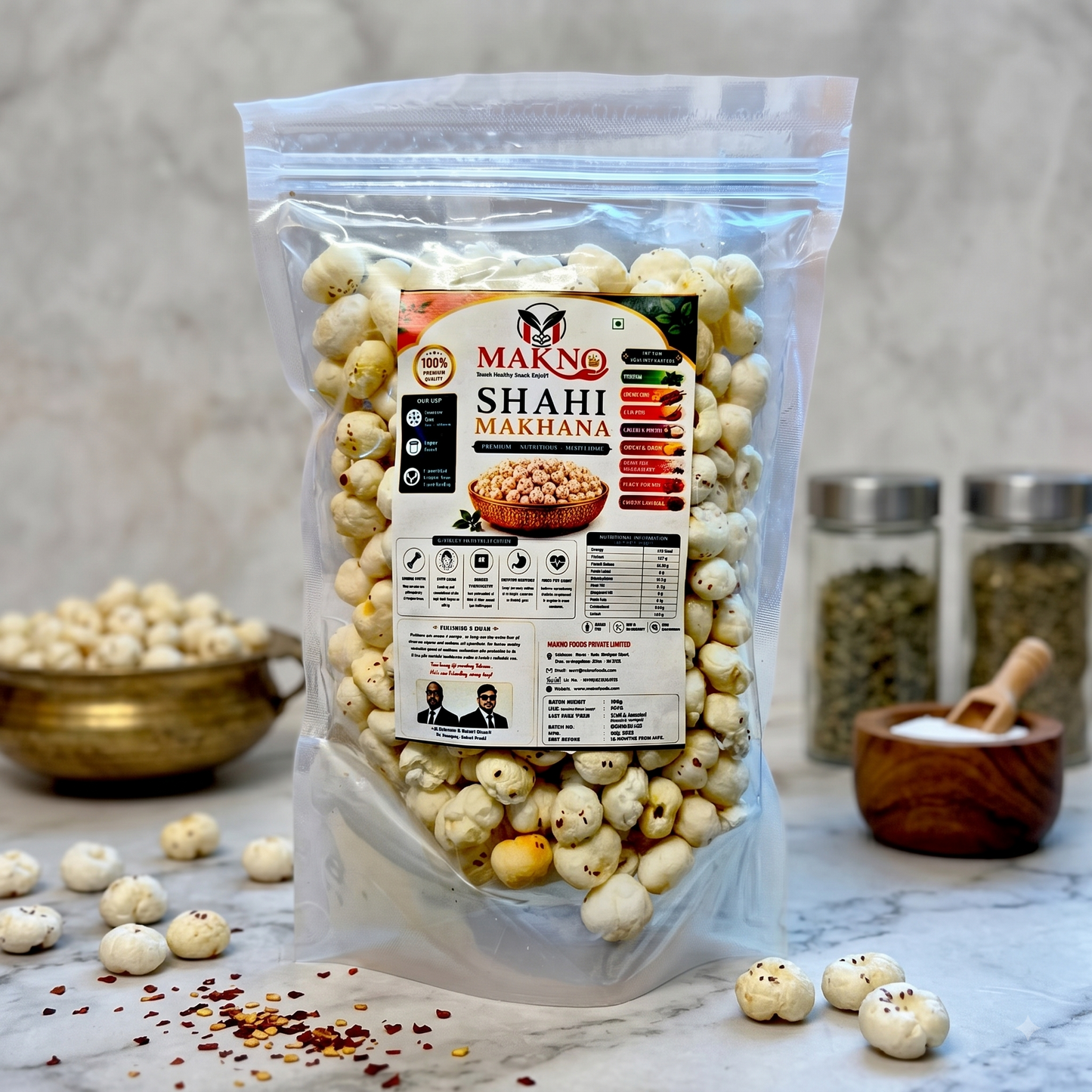 Makno Shahi Makhana 100g pouch styled on a marble counter with a brass bowl and spices